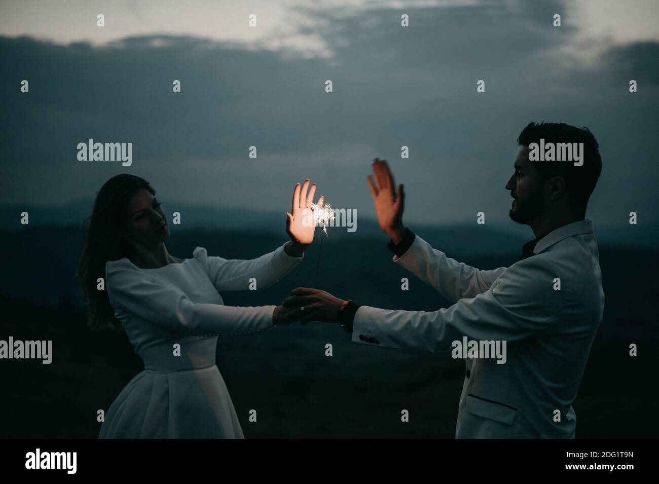 Happy Young Couple Playing with a firework at night After wedding Stock Photo