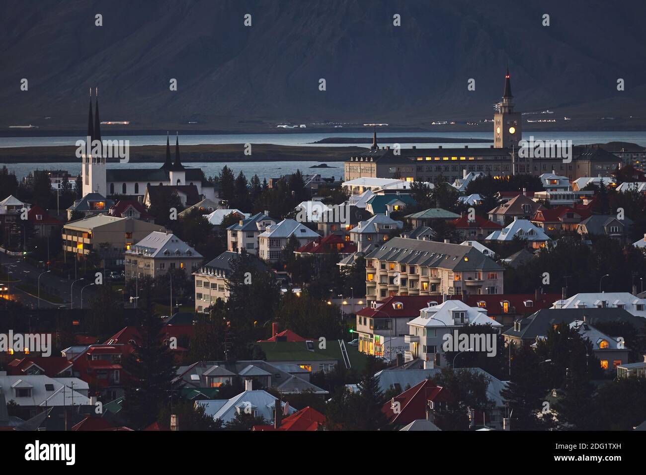 Beautiful night dusk view of Reykjavik, Iceland, aerial view with Hallgrimskirkja lutheran church, with scenery beyond the city, Esja mountain and Fax Stock Photo