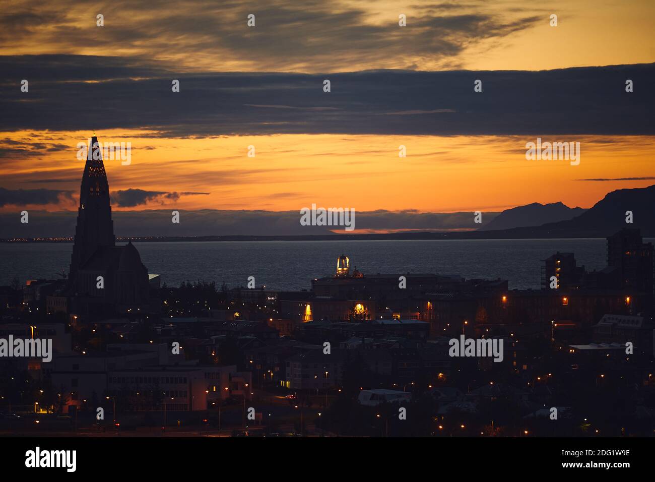 Beautiful night dusk view of Reykjavik, Iceland, aerial view with Hallgrimskirkja lutheran church, with scenery beyond the city, Esja mountain and Fax Stock Photo