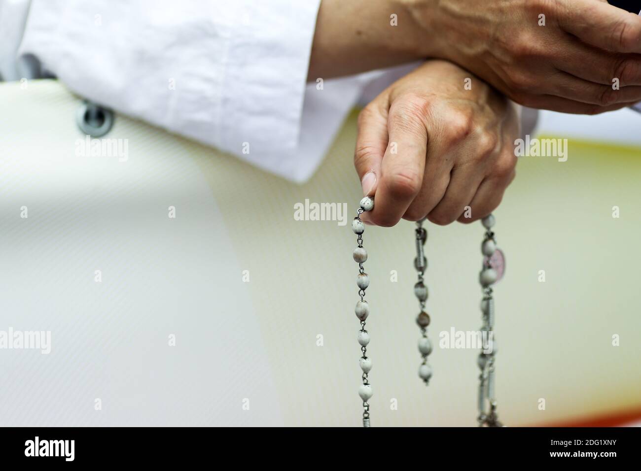 Details with the hands of a catholic nun holding a rosary. Stock Photo