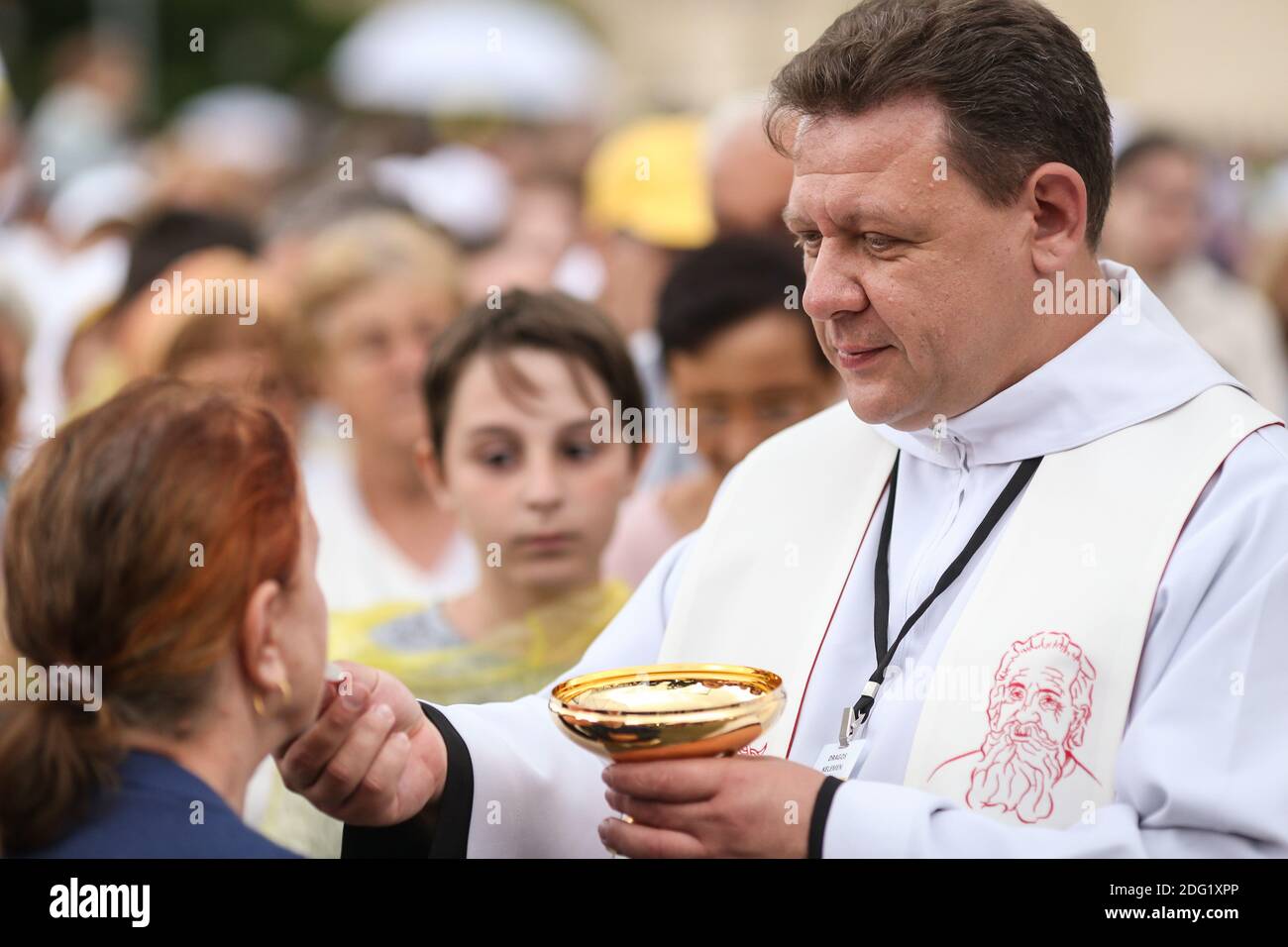 Bucharest, Romania - May 31, 2019: A catholic priest is giving communion to people gathered in a Bucharest square. Stock Photo