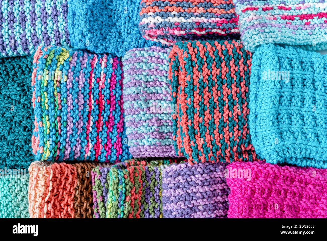 A colorful array of homemade knitted cotton dish clothes. Stock Photo