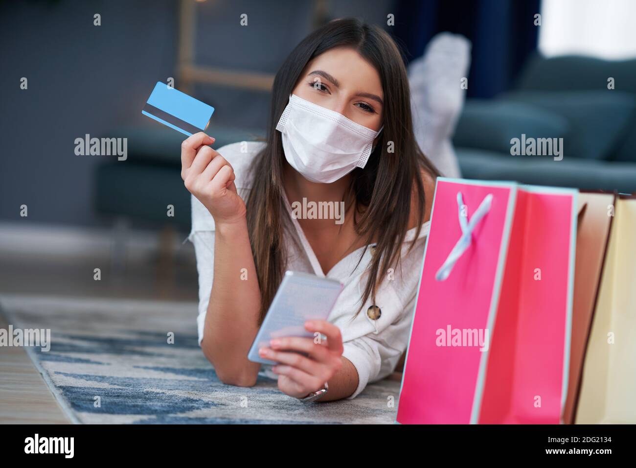 Pretty woman in mask shopping online with credit card Stock Photo - Alamy