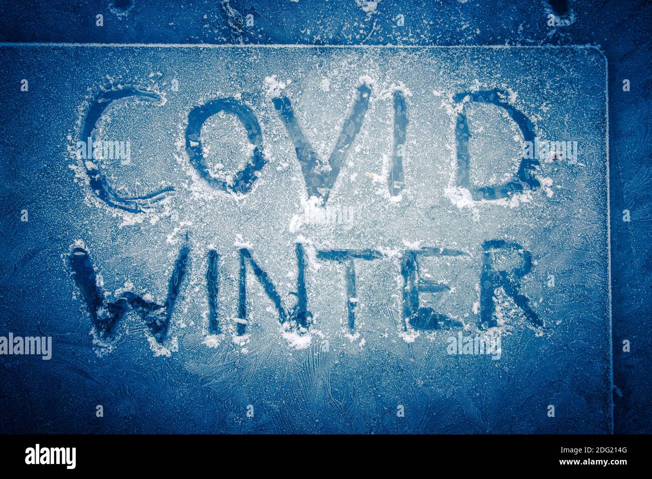 Winter Covid, Stay at home Coronavirus words written in frozen glass as winter takes hold with icy mornings in the UK as the country comes out of its Stock Photo