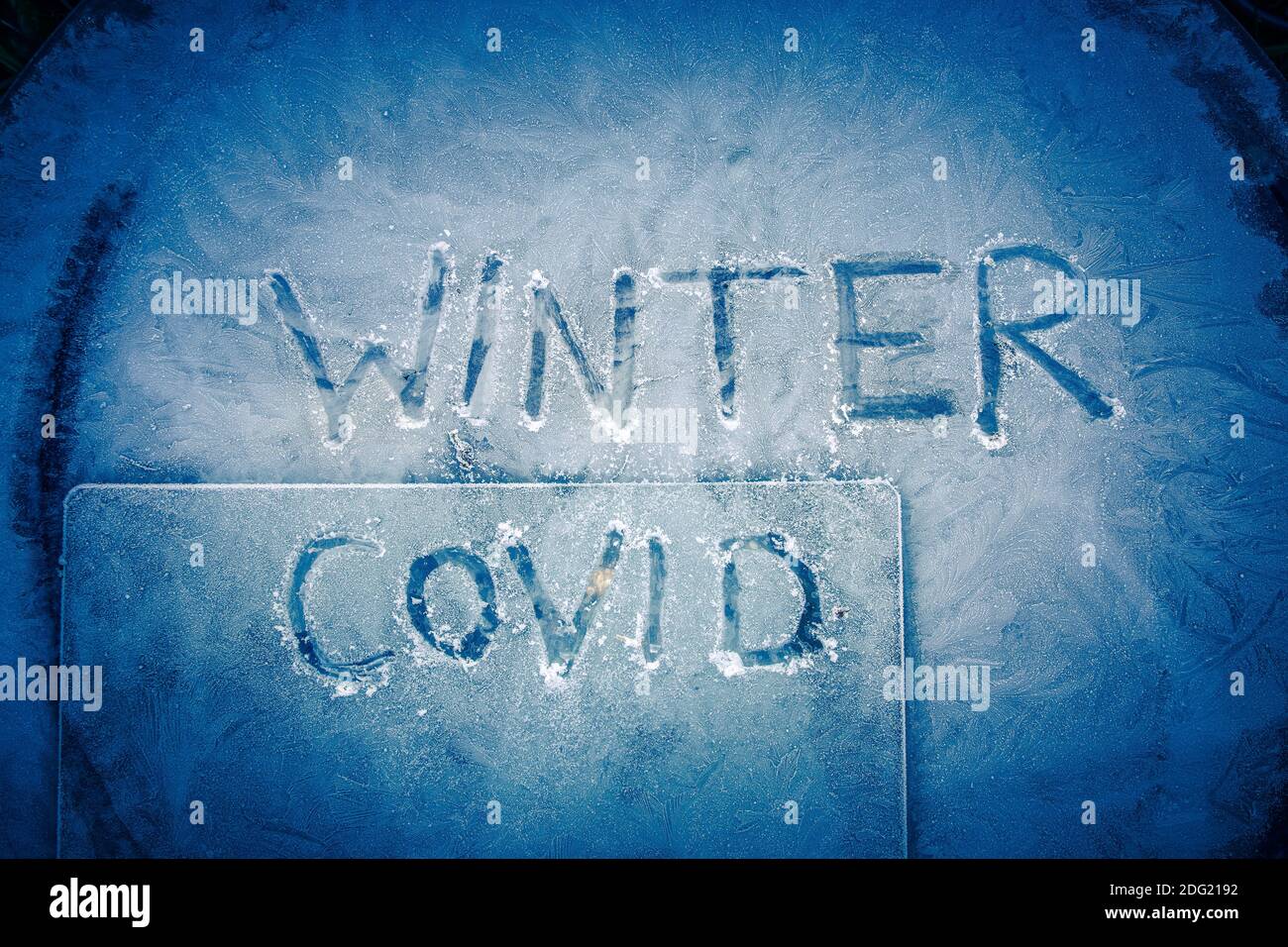 Winter Covid, Stay at home Coronavirus words written in frozen glass as winter takes hold with icy mornings in the UK as the country comes out of its Stock Photo