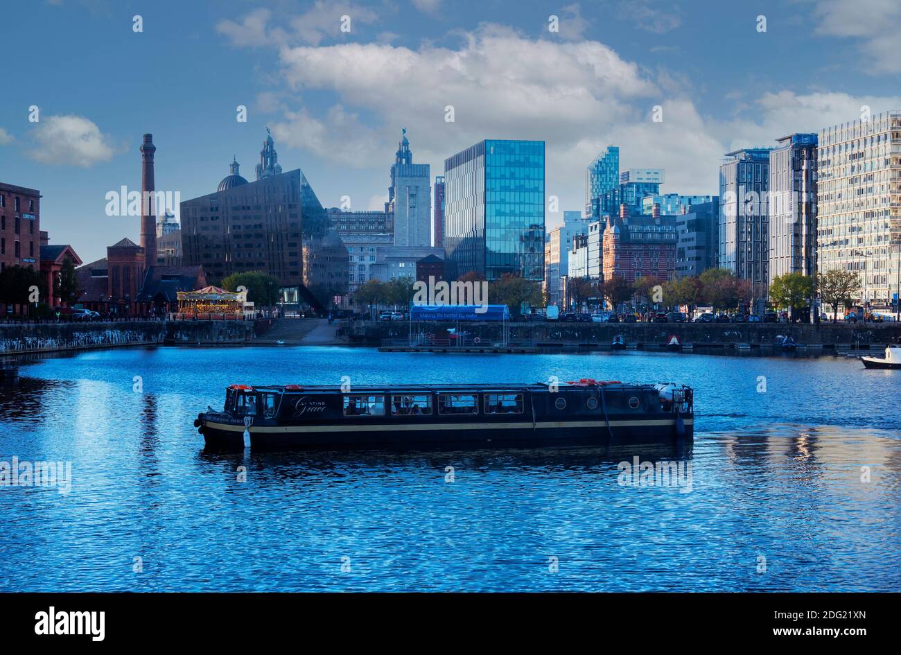 Barge carrying tourists at dusk in Royal Albert Dock in Liverpool Stock Photo