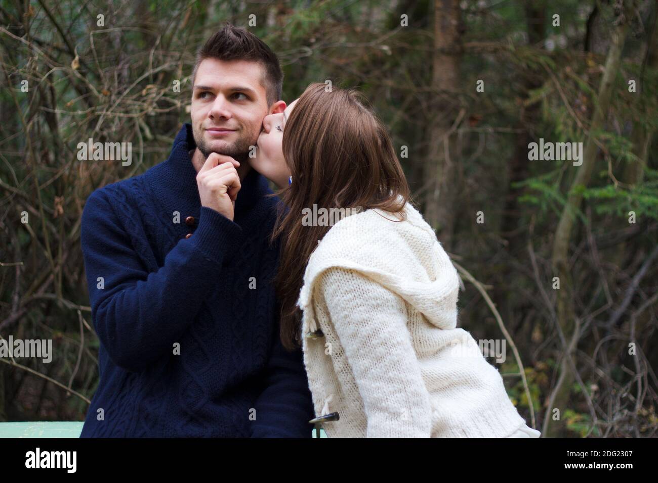 Young couple holding hands in the forest in front of trees Stock Photo ...