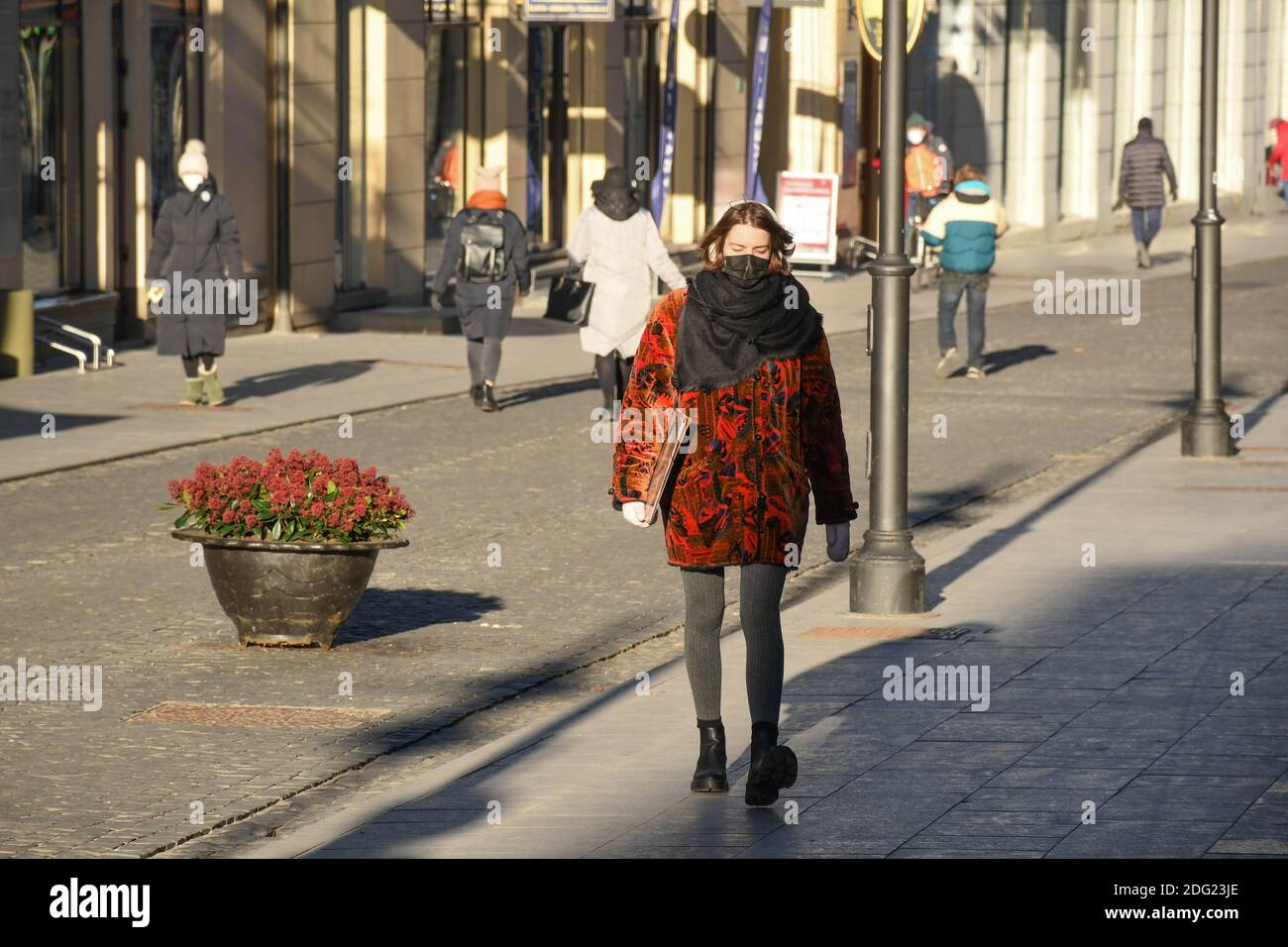 Beautiful young girl wearing mask and walking in the city for shopping during Covid or Coronavirus outbreak Stock Photo
