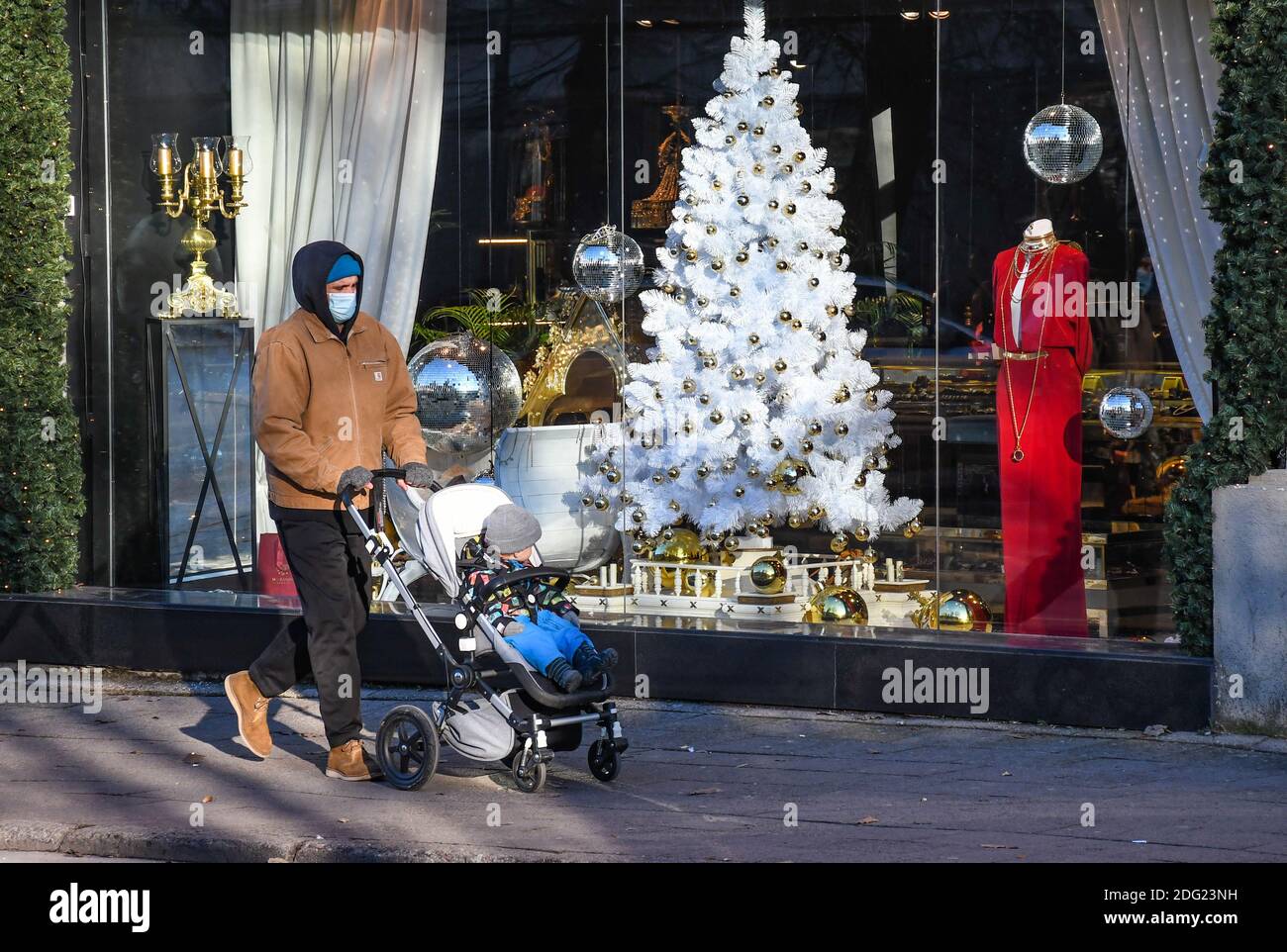 Man with stroller walking in the city near a shop or shopping center during Covid or Coronavirus outbreak, Christmas background Stock Photo