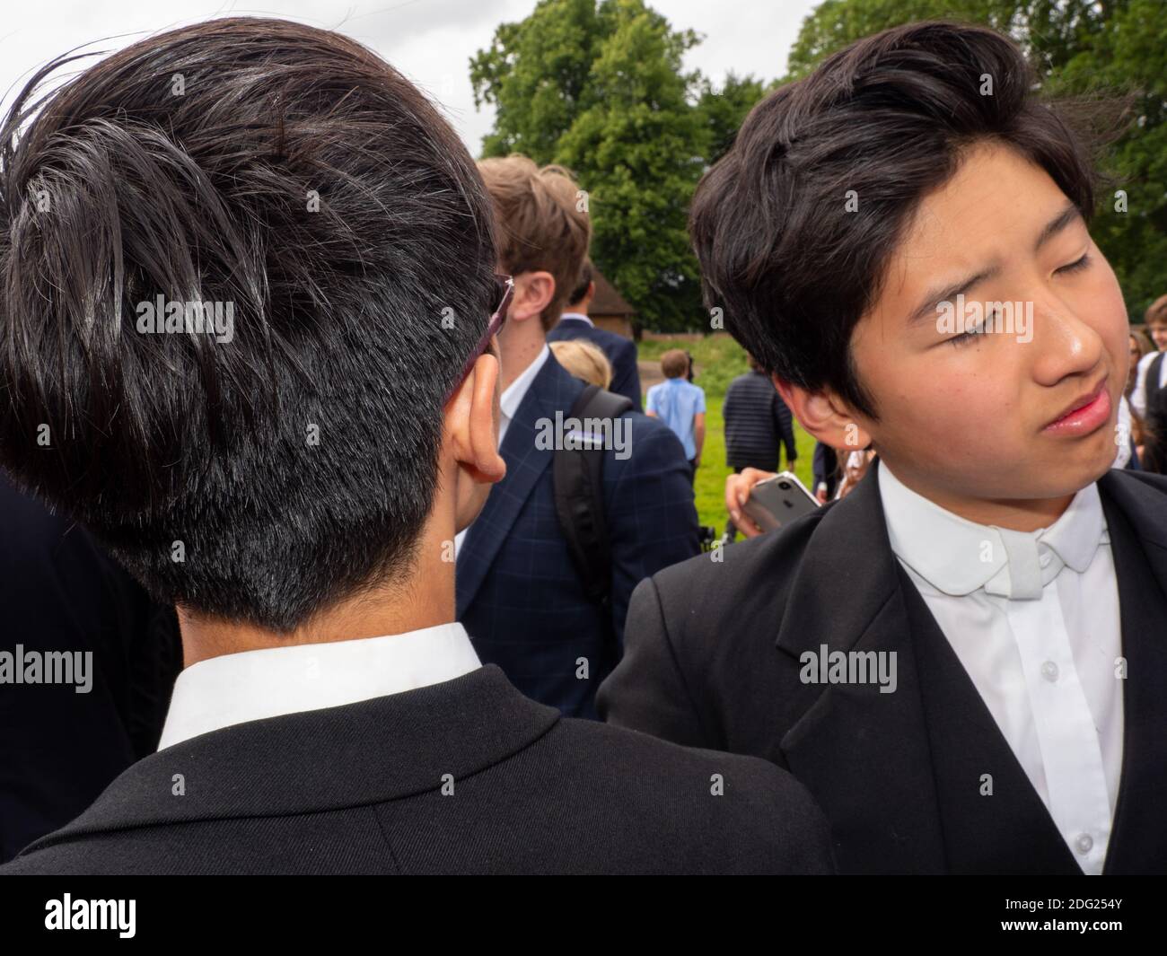 Eton College school boys wearing the traditional white collar and black jacket. Stock Photo