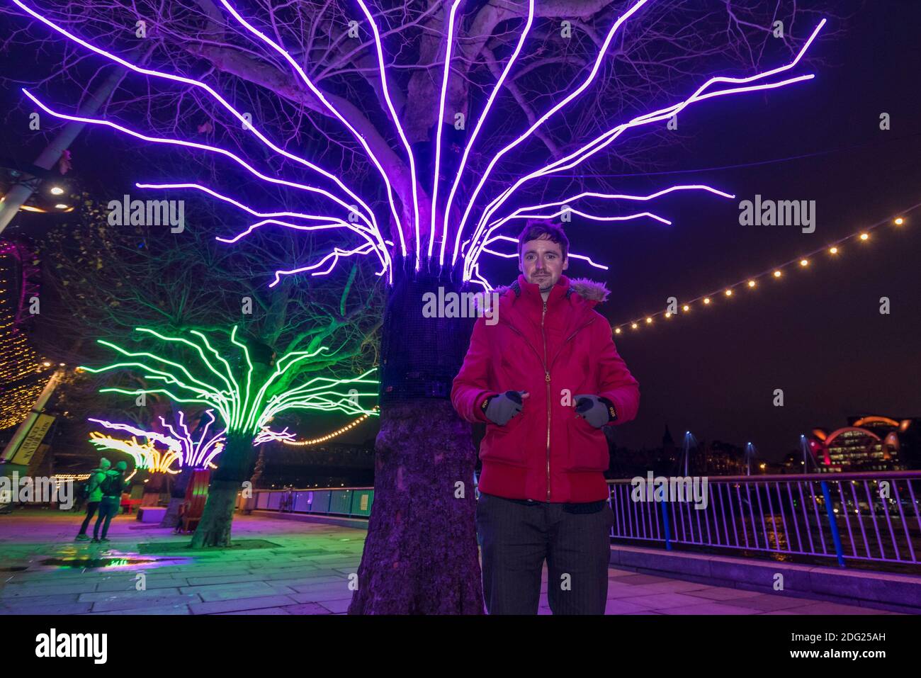 London, UK.  7 December 2020. Artist David Ogle in front of his work "Lumen", trees illuminated with glowing neon flex. Preview of “Winter Light” presented by Southbank Centre.  Over 15 artworks and new illuminated commissions by a range of leading international artists are on display around the site’s buildings and the Riverside Walk until the end of February 2021. Credit: Stephen Chung / Alamy Live News Stock Photo
