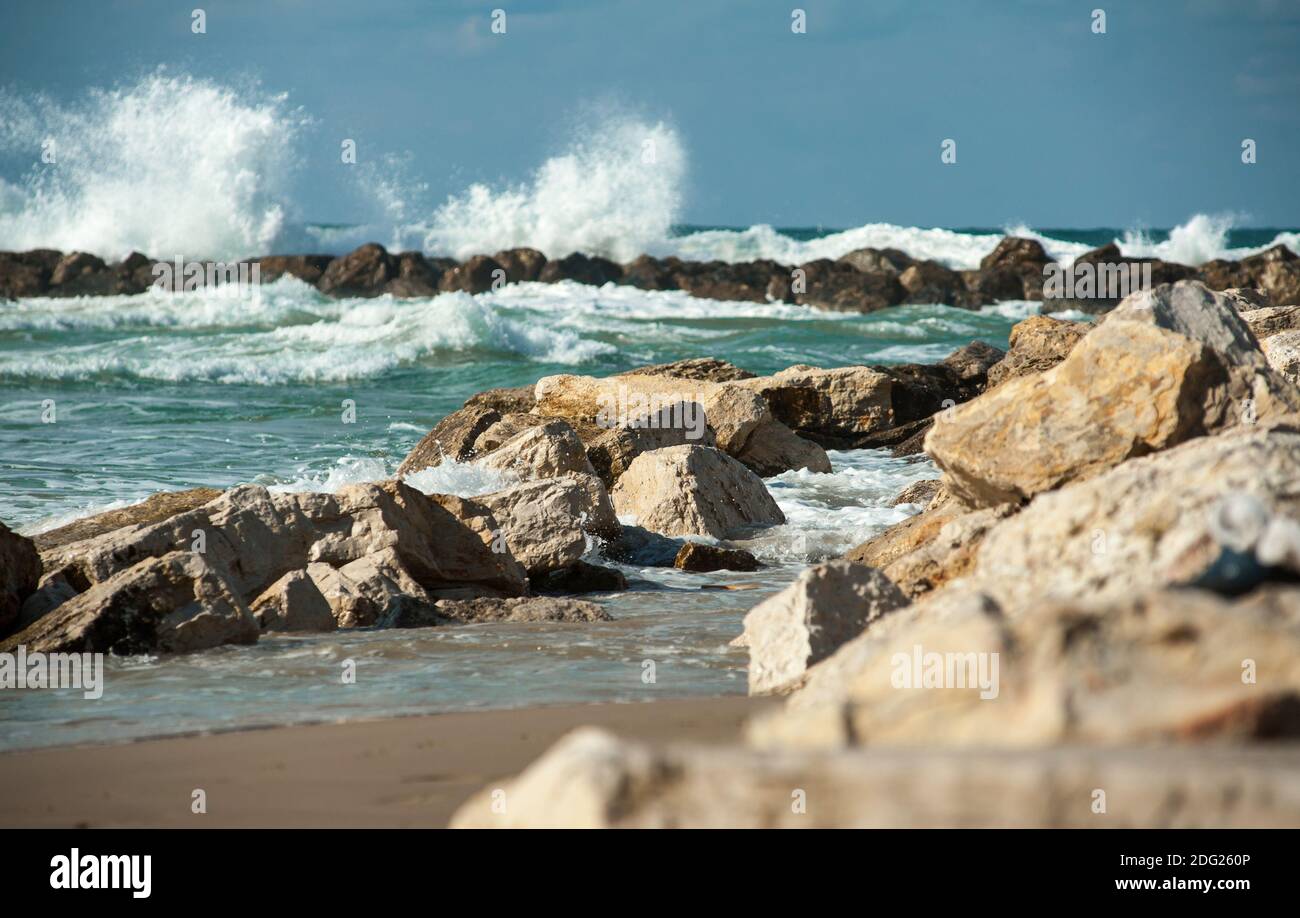 Stones laying on seaside with waves crushing behind on a background Stock Photo