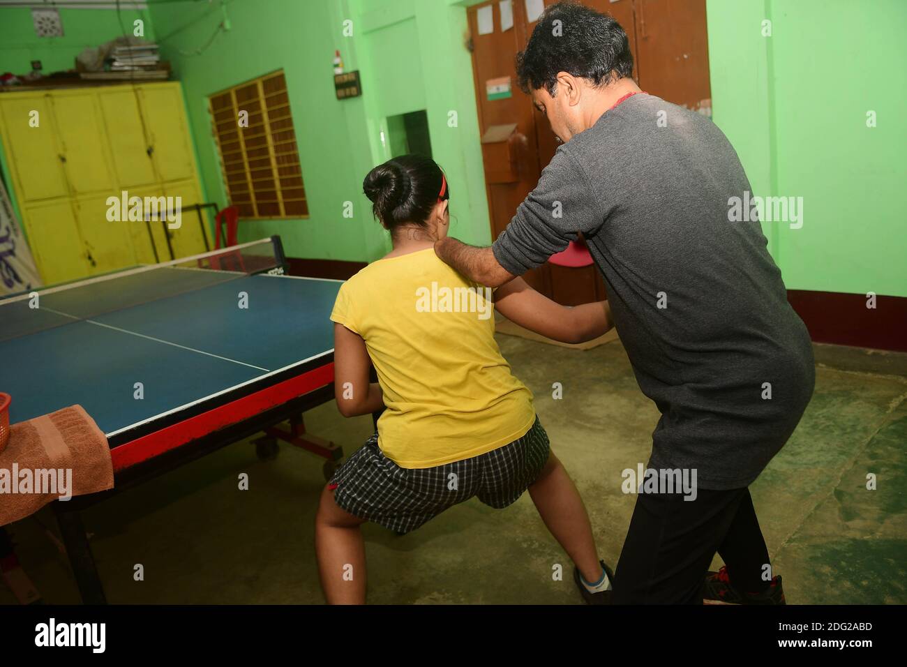 Kajol Dey, a 49 year old disabled table tennis player and coach is seen coaching a young girl at his coaching camp on International Day of Persons with Disabilities (IDPD). Agartala, Tripura, India. Stock Photo