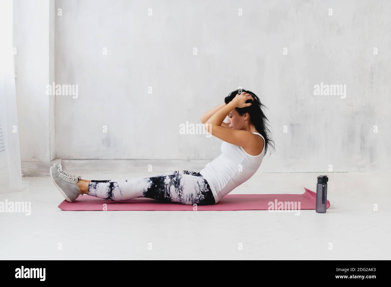 Woman lying on athletic mat and making an abs workout. Stock Photo