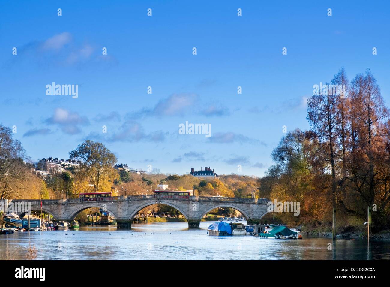 London, Richmond, 18th Century stone arch Richmond Bridge, affluent residential suburb in west London, Thames River, Autumn, boats, trees in fall Stock Photo