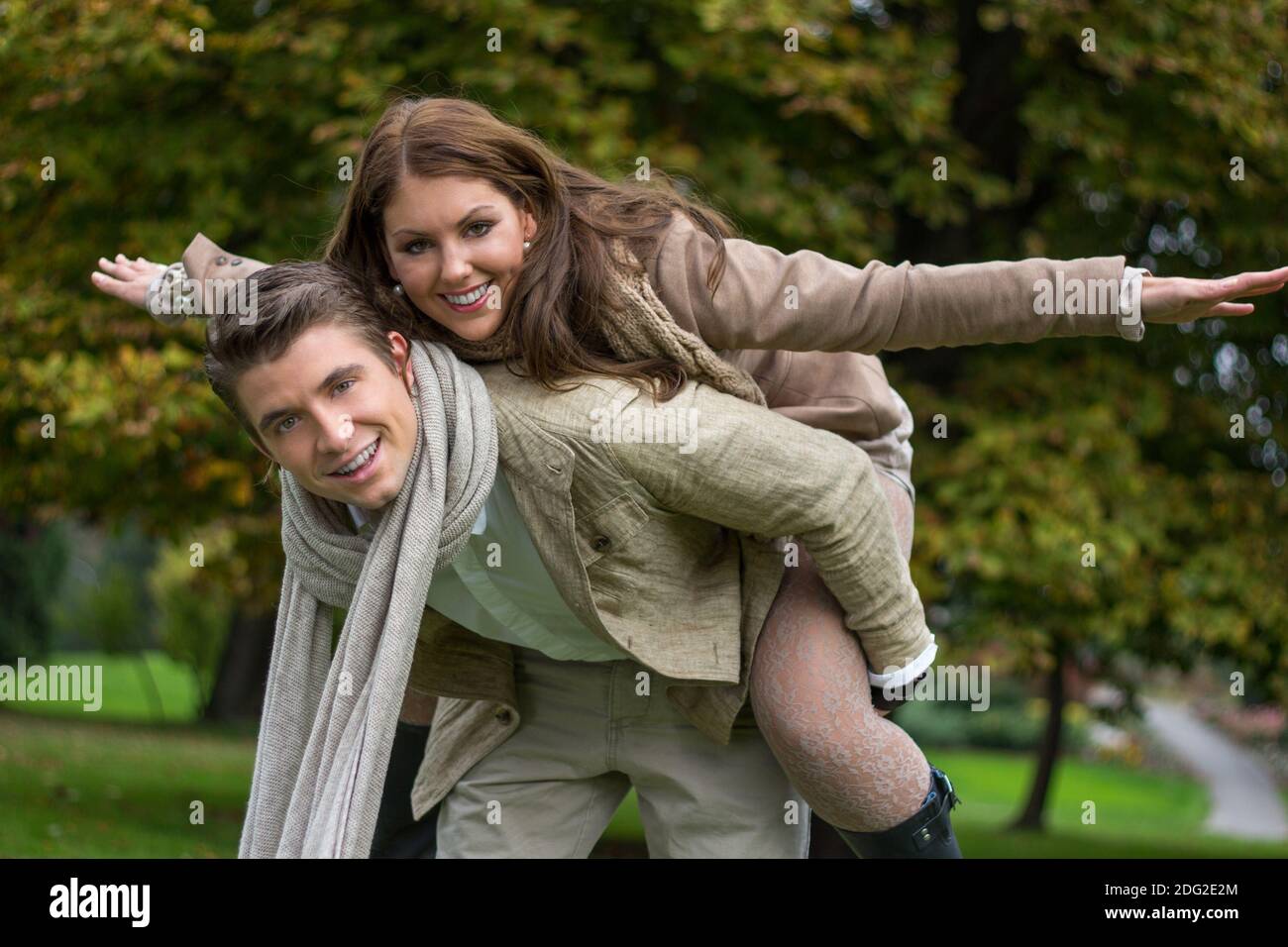 Young couple in love piggyback at a park Stock Photo - Alamy