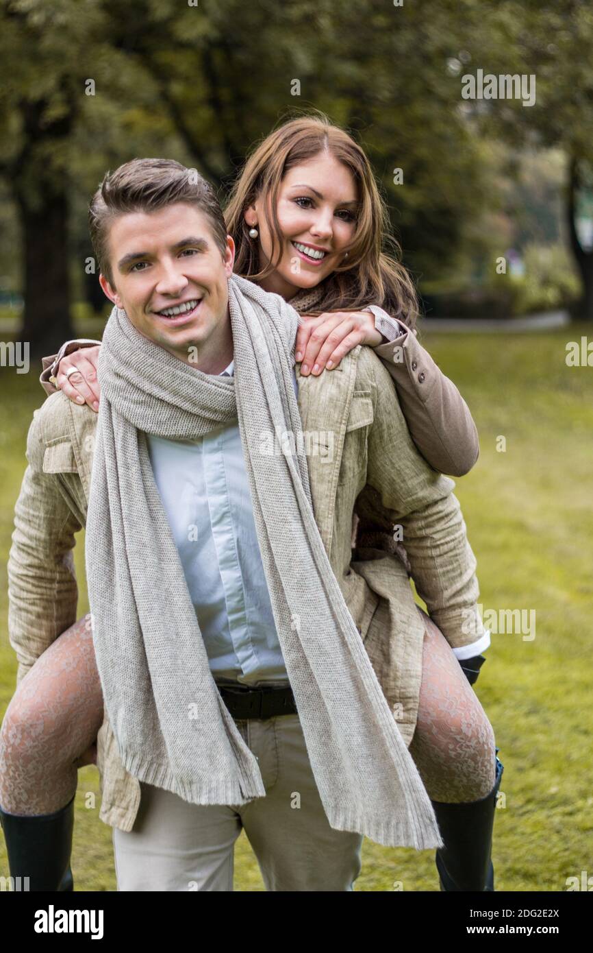 Young couple in love piggyback at a park Stock Photo - Alamy