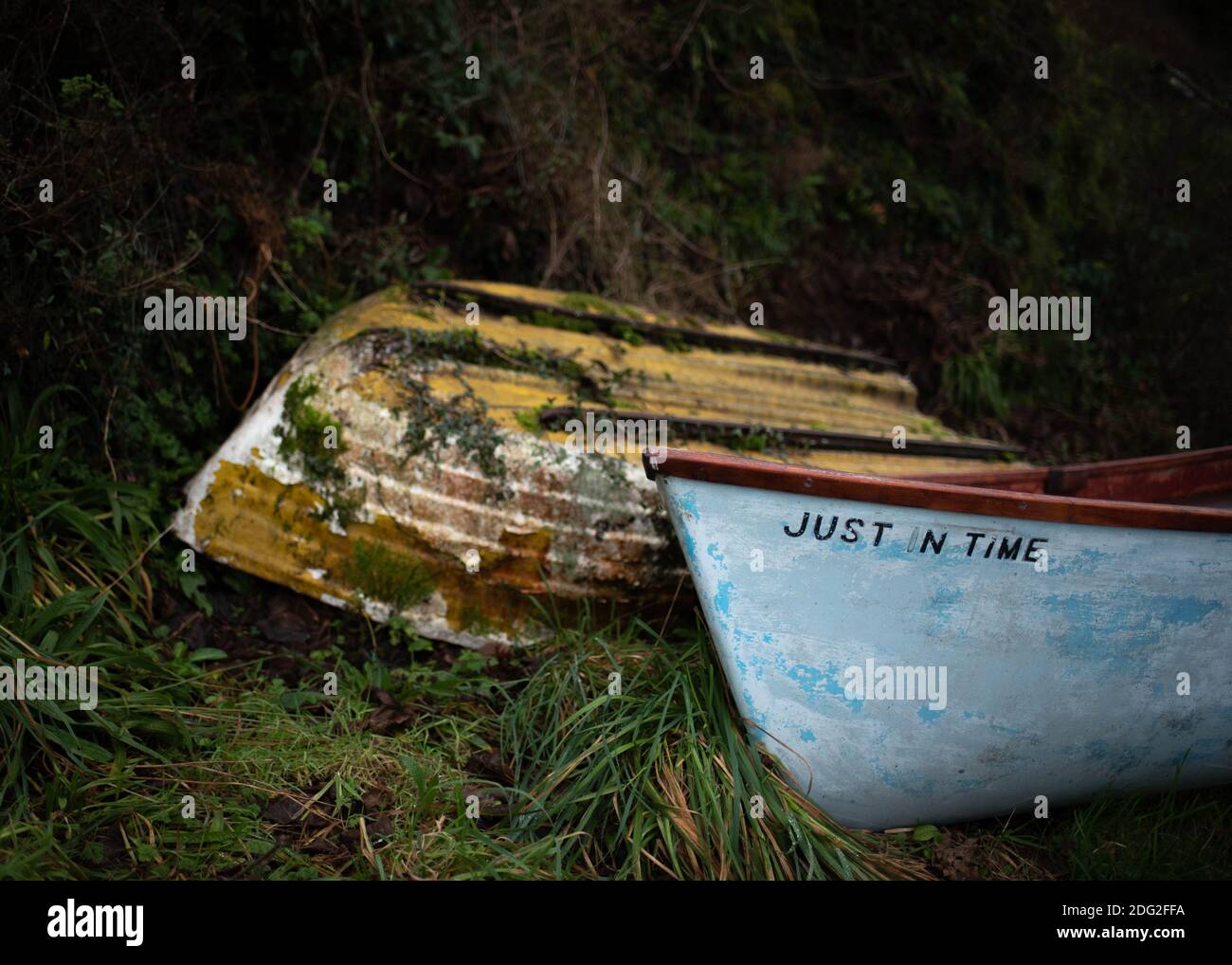 Two boats sitting ashore at Bucks Mills in Devon, South West England in November 2020.  One named Just in Time, with one abandoned next to it. Stock Photo
