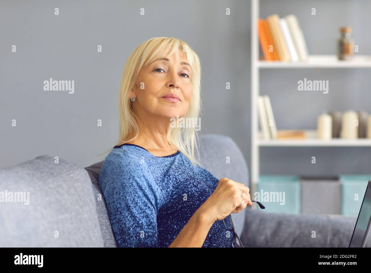 Mature woman sitting on sofa hi-res stock photography and images - Alamy