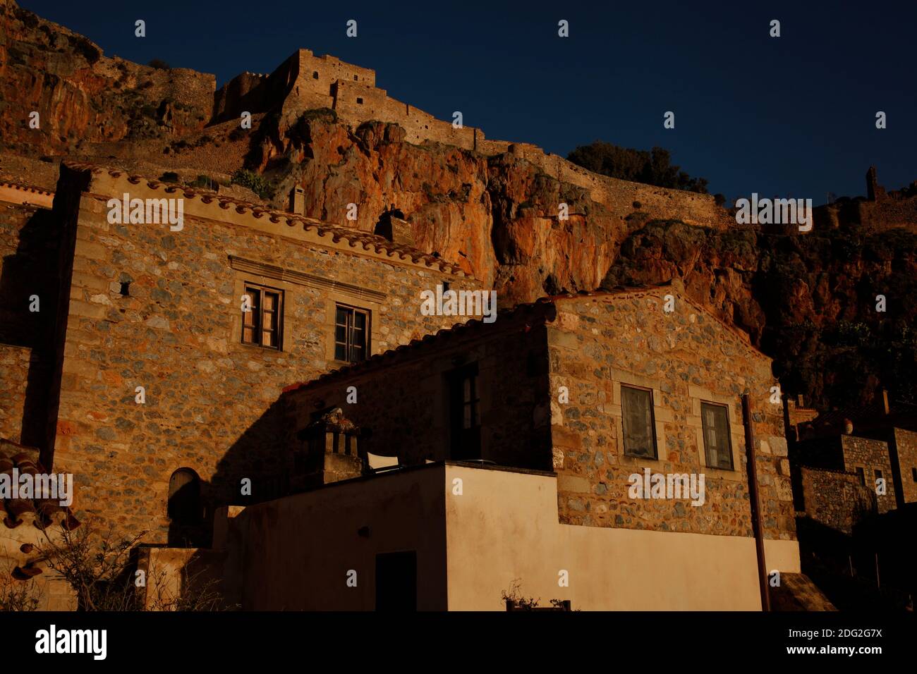Traditional stone homes stand below a medieval fortress overlooking the