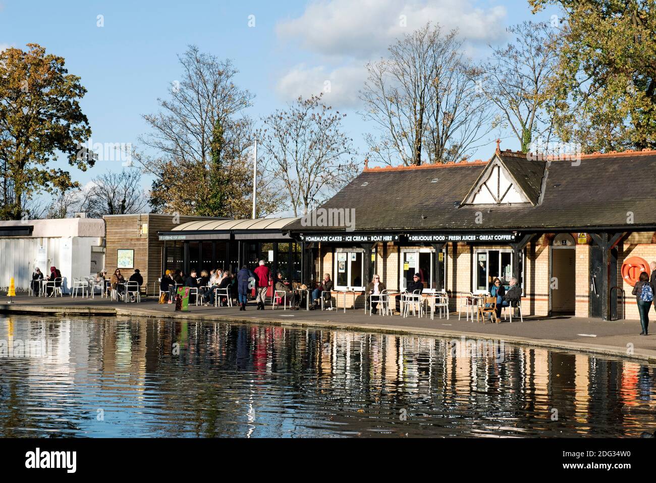 Lakeside Café with people outside at tables seen across boating lake Alexandra Palace Park, London Borough of Haringey Stock Photo