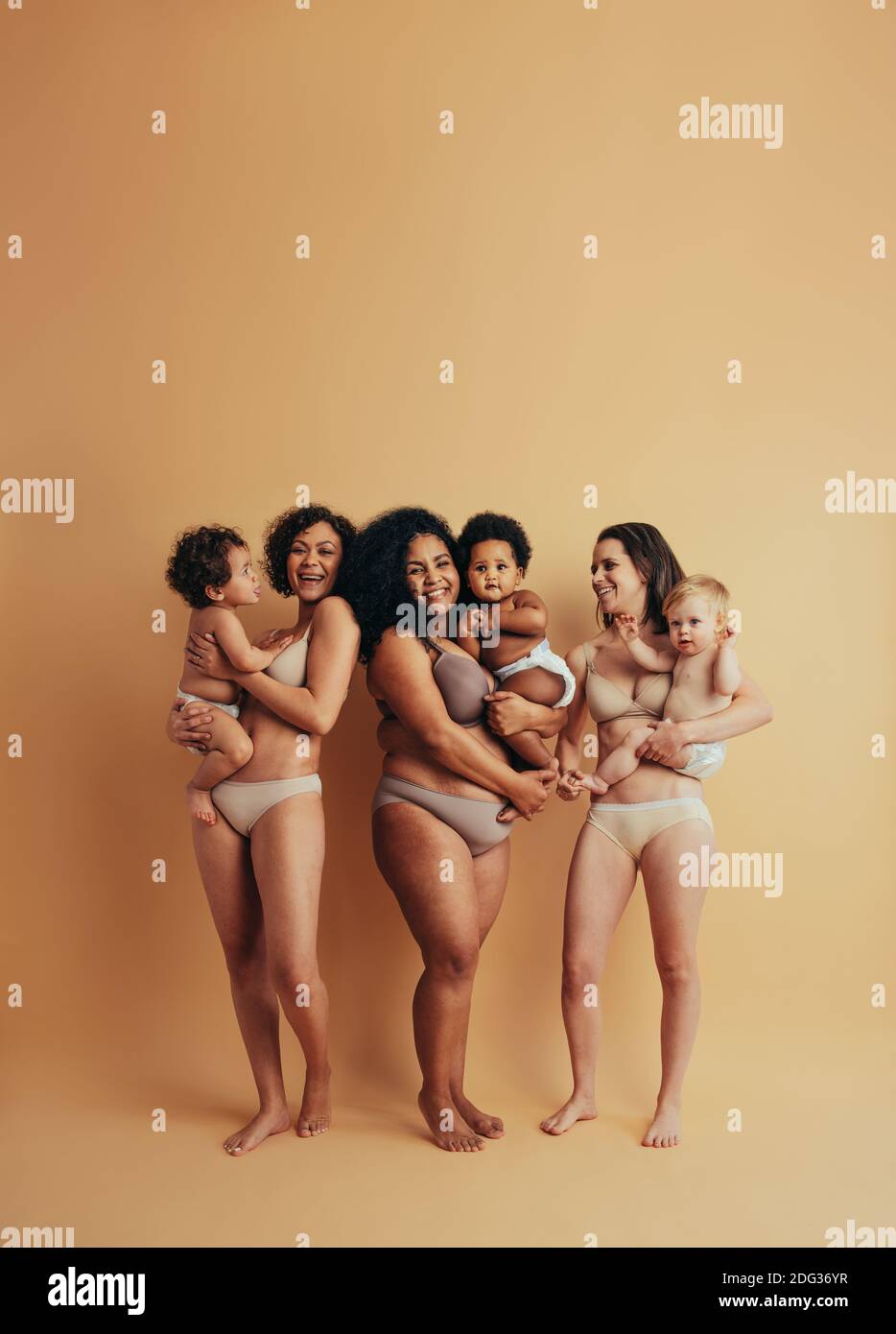 Women holding her babies. Strong and positive women. Mothers embracing their bodies. Stock Photo