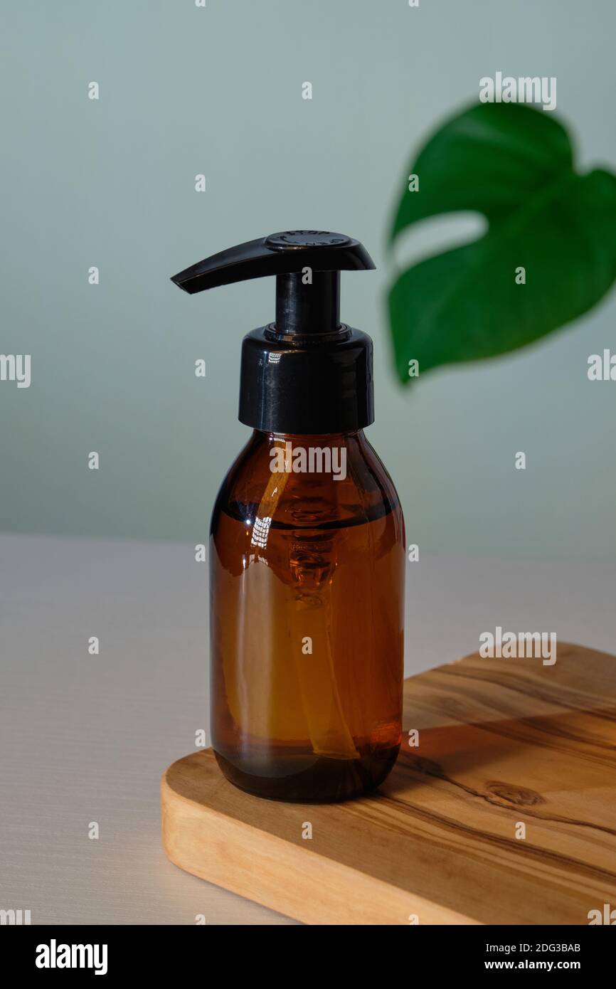 Download Clear Amber Glass Pump Bottle Mockup With Tropical Green Leaf Dispenser Packaging Design For Natural Organic Cosmetics Stock Photo Alamy