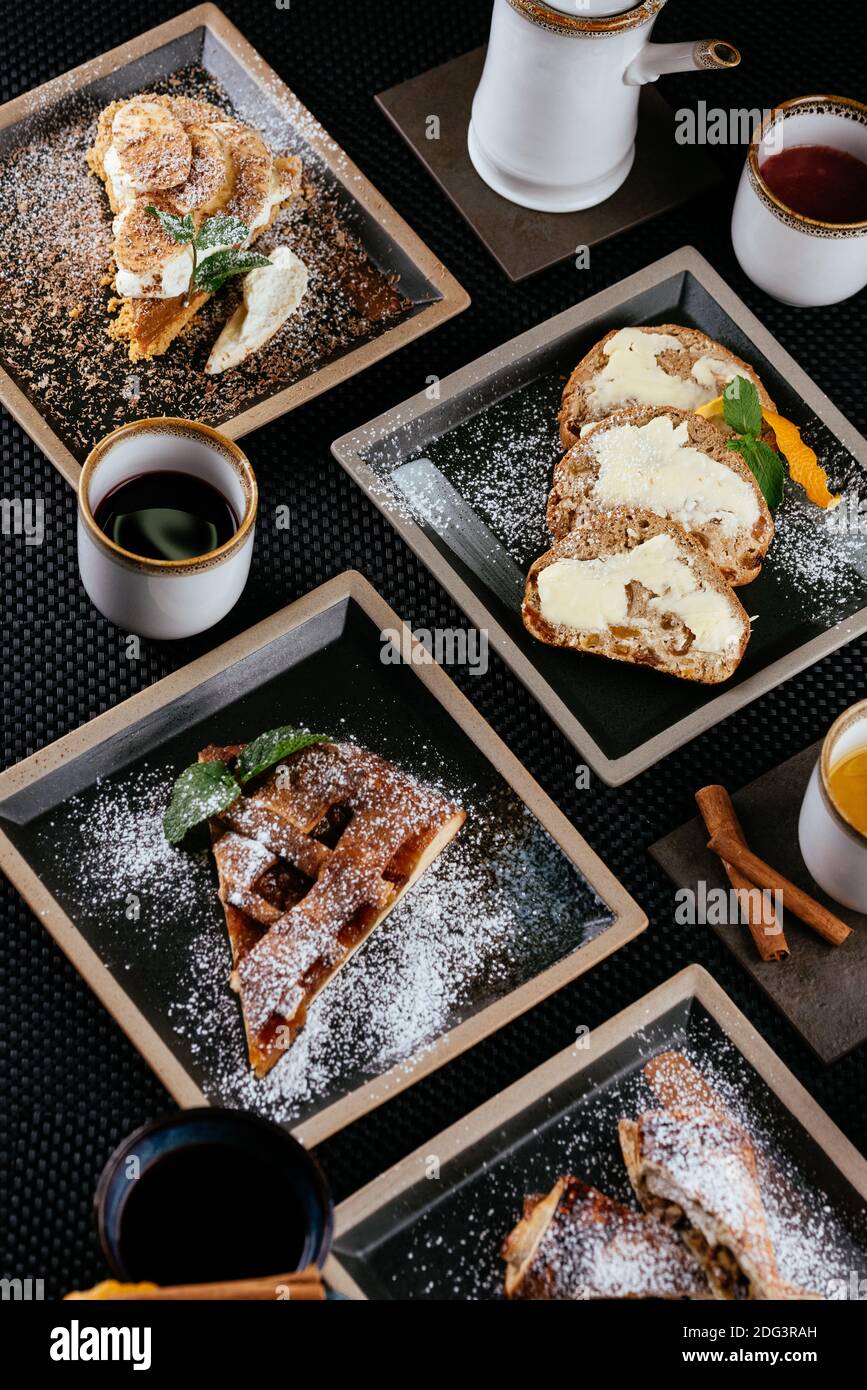 various desserts with tea on a black background Stock Photo