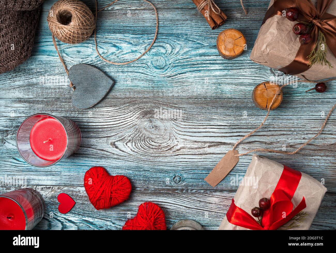Hearts and gift boxes with candles on a wooden background. Stock Photo