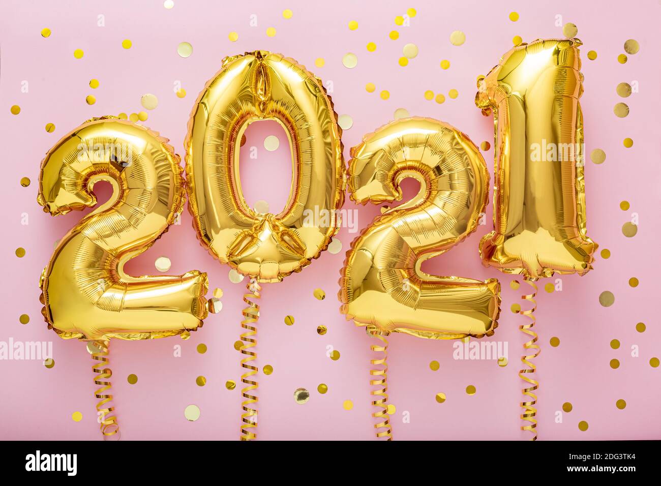 2021 air balloon gold numbers with ribbons golden confetti on pink background, Christmas, Happy New year eve decor with gold foil balloons 2021 Stock Photo