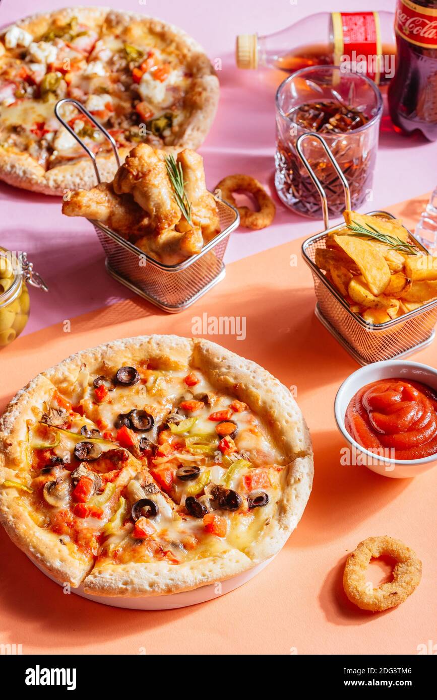 Italian pizza with vegetables, chicken wings, potatoes, sauce Stock Photo