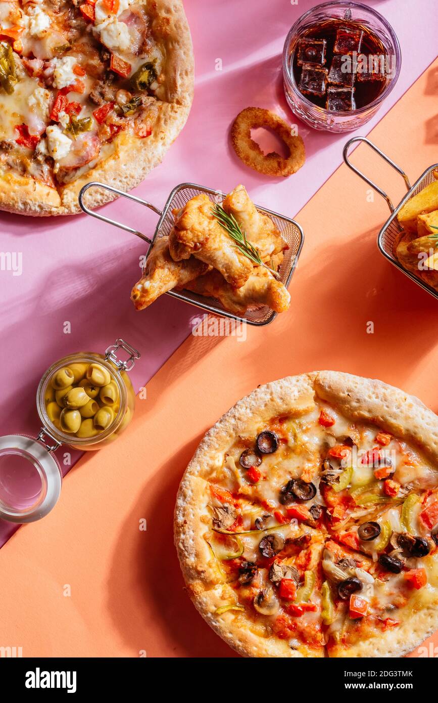 Italian pizza with vegetables, chicken wings, potatoes, sauce Stock Photo