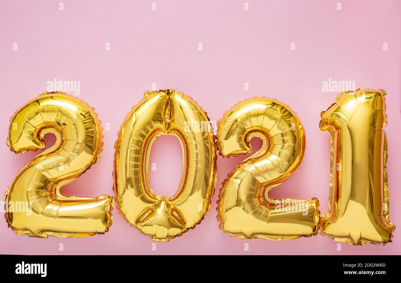 2021 air balloon gold numbers on pink background. Christmas Happy New year eve decor with gold foil balloons 2021 Copy space Top view Stock Photo