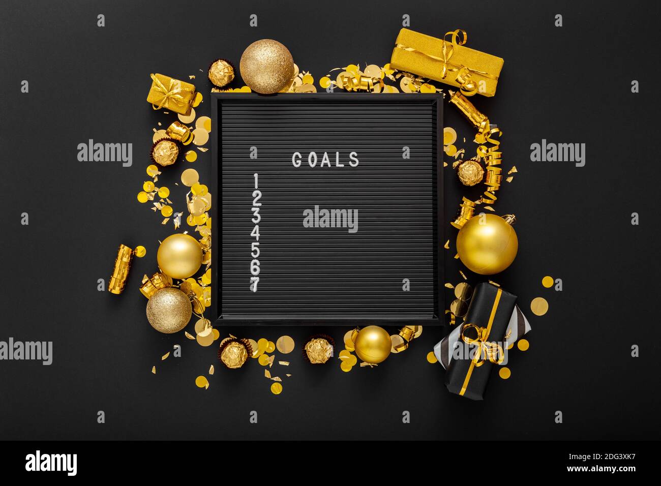 Numbered list of 2021 Goals on black Board in frame made of gold festive decor, gift boxes, confetti. New year eve 2021 goals, resolution check list Stock Photo