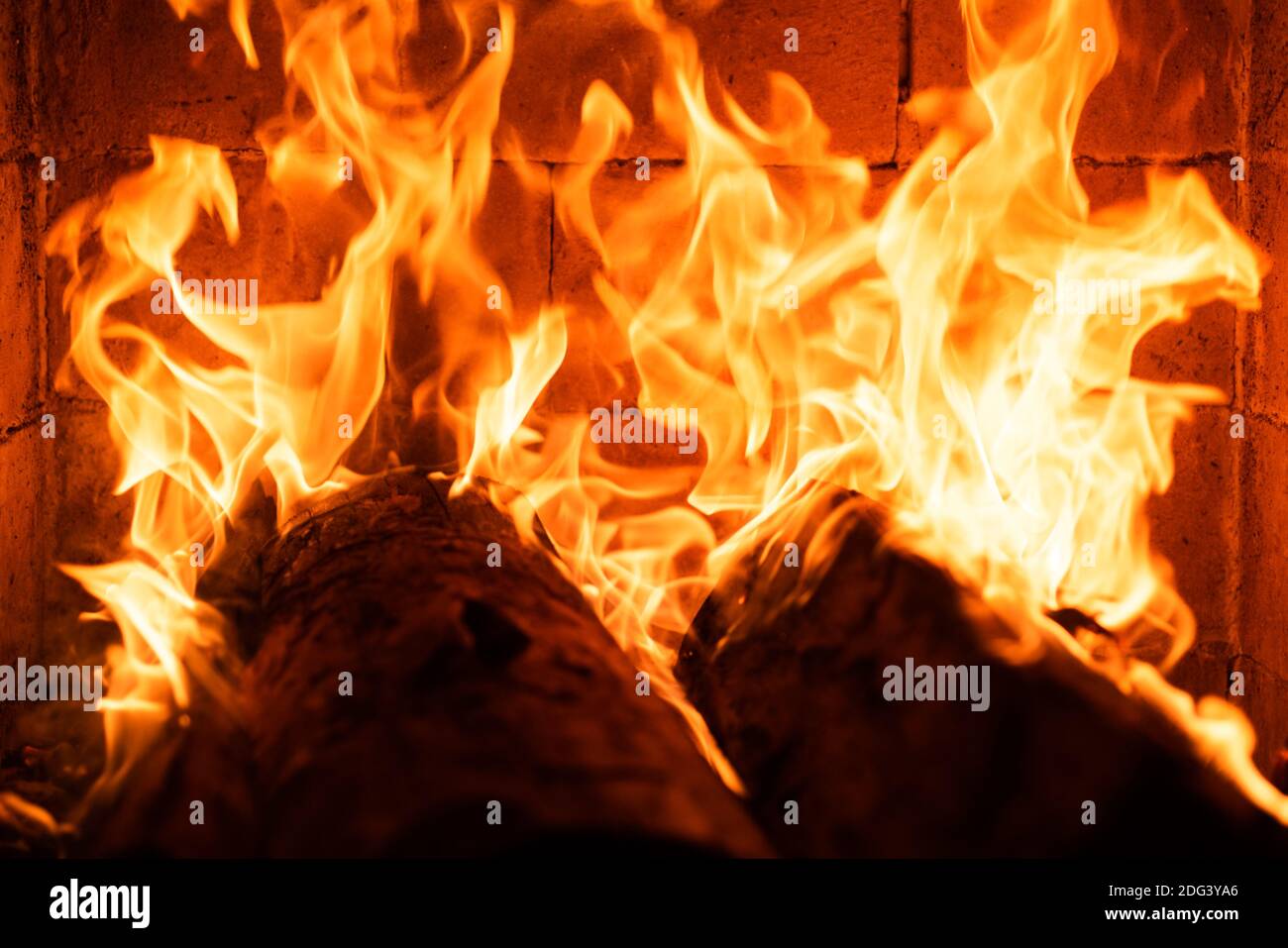 Glowing fire in a huge stone fireplace. Fire flame texture. Abstract