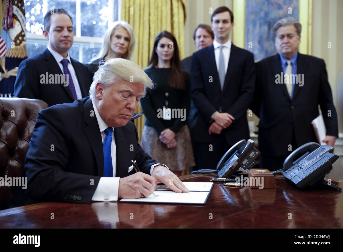 US President Donald Trump (F), with White House chief of staff Reince Pribus (L), counselor to the President Kellyanne Conway (2L), White House Communications Director Hope Hicks (3L), Senior Advisor Jared Kushner (2R) and Senior Counselor Stephen Bannon (R), signs one of five executive orders related to the oil pipeline industry in the oval office of the White House in Washington, DC, USA, 24 January 2017. President Trump has a full day of meetings including one with Senate Majority Leader Mitch McConnell and another with the full Senate leadership. Photo by Pool/ABACAPRESS.COM Stock Photo