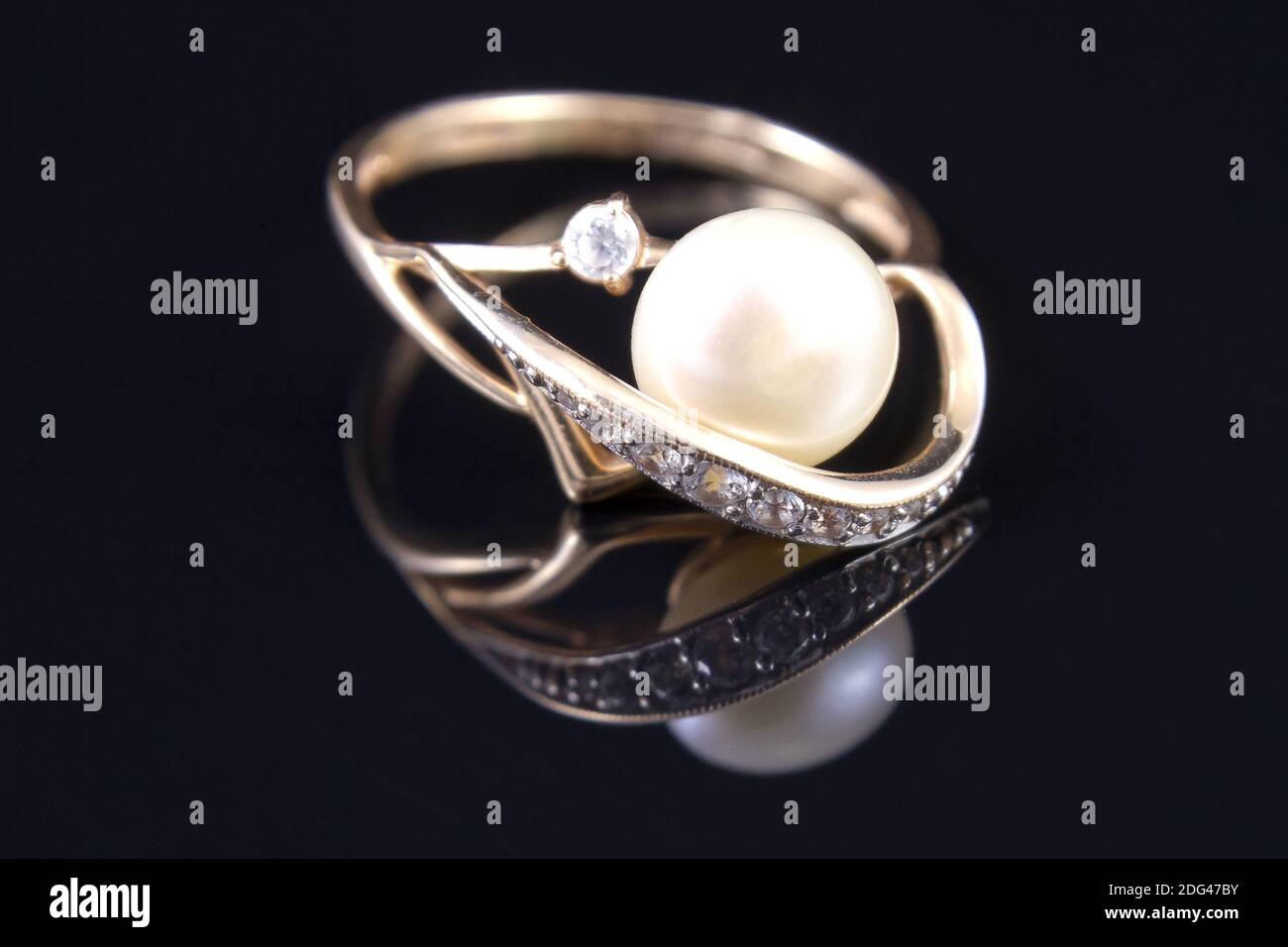 Gold ring with a pearl is reflected from the floor Stock Photo