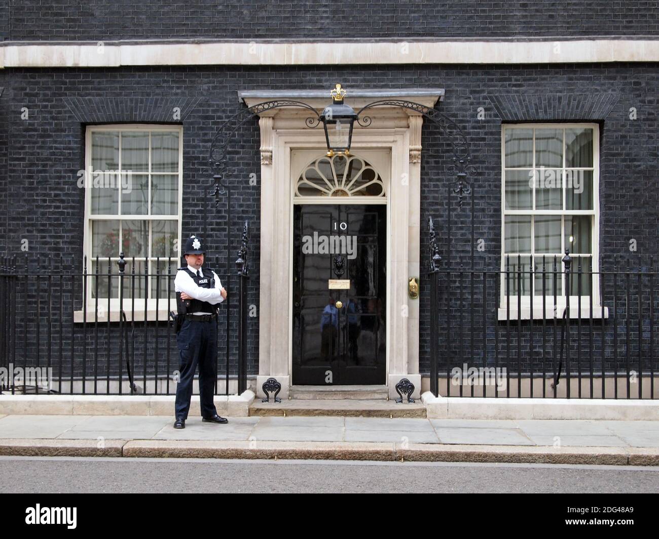 Police officer guarding the door of 10 Downing Street, London, UK Stock Photo