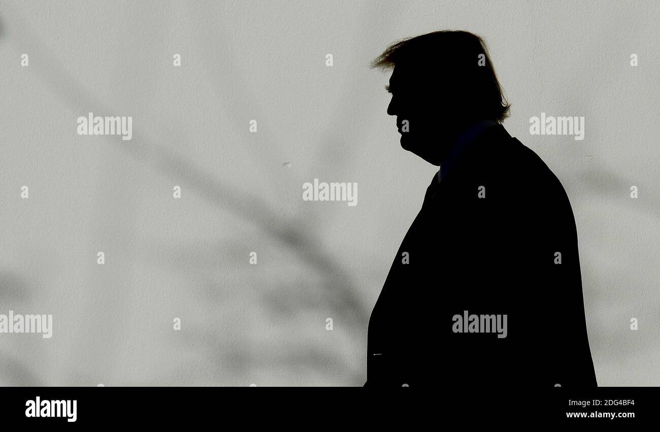 US President Donald Trump walks back to the Oval Office of the White ...