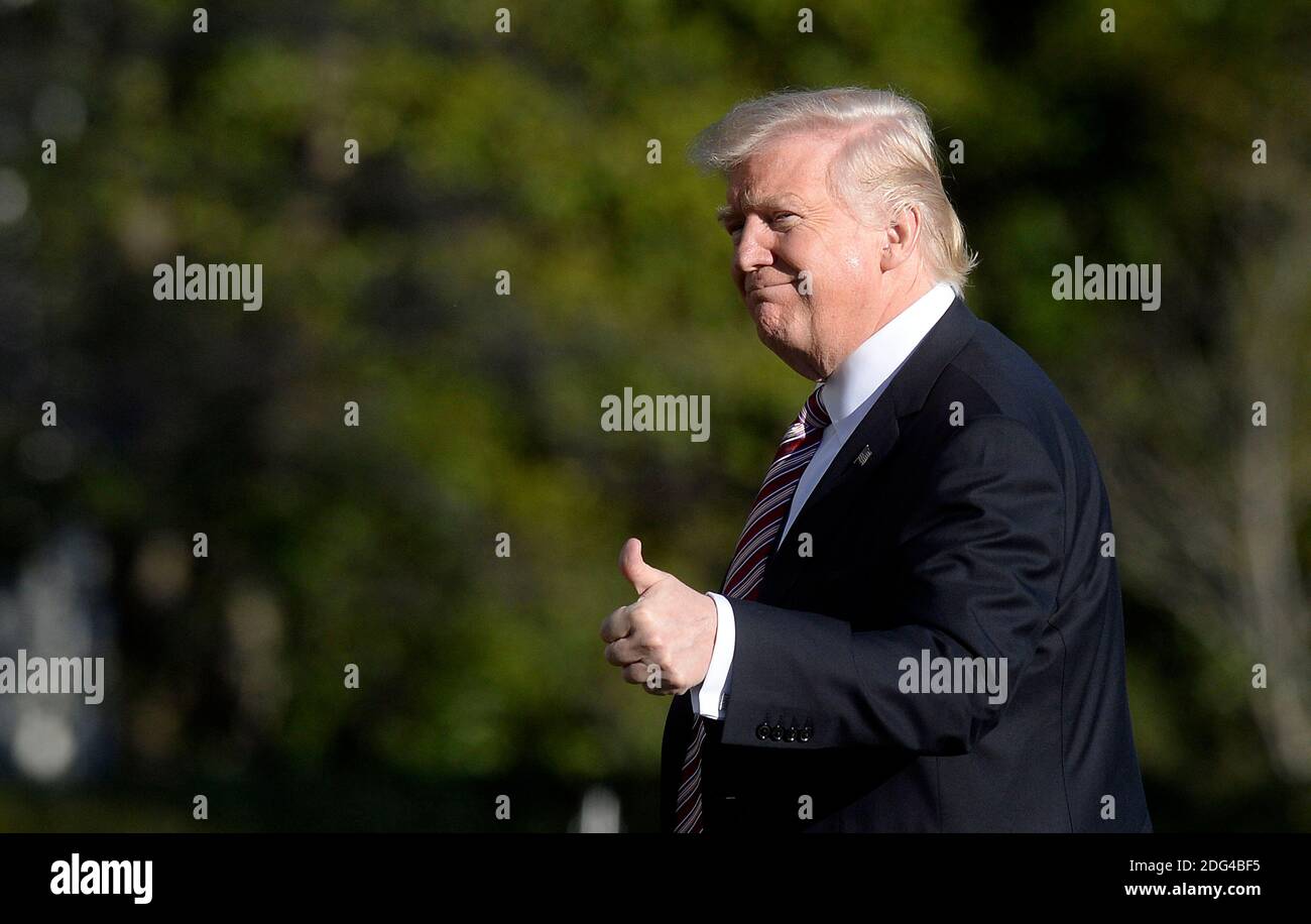 US President Donald Trump walks back to the Oval Office of the White ...