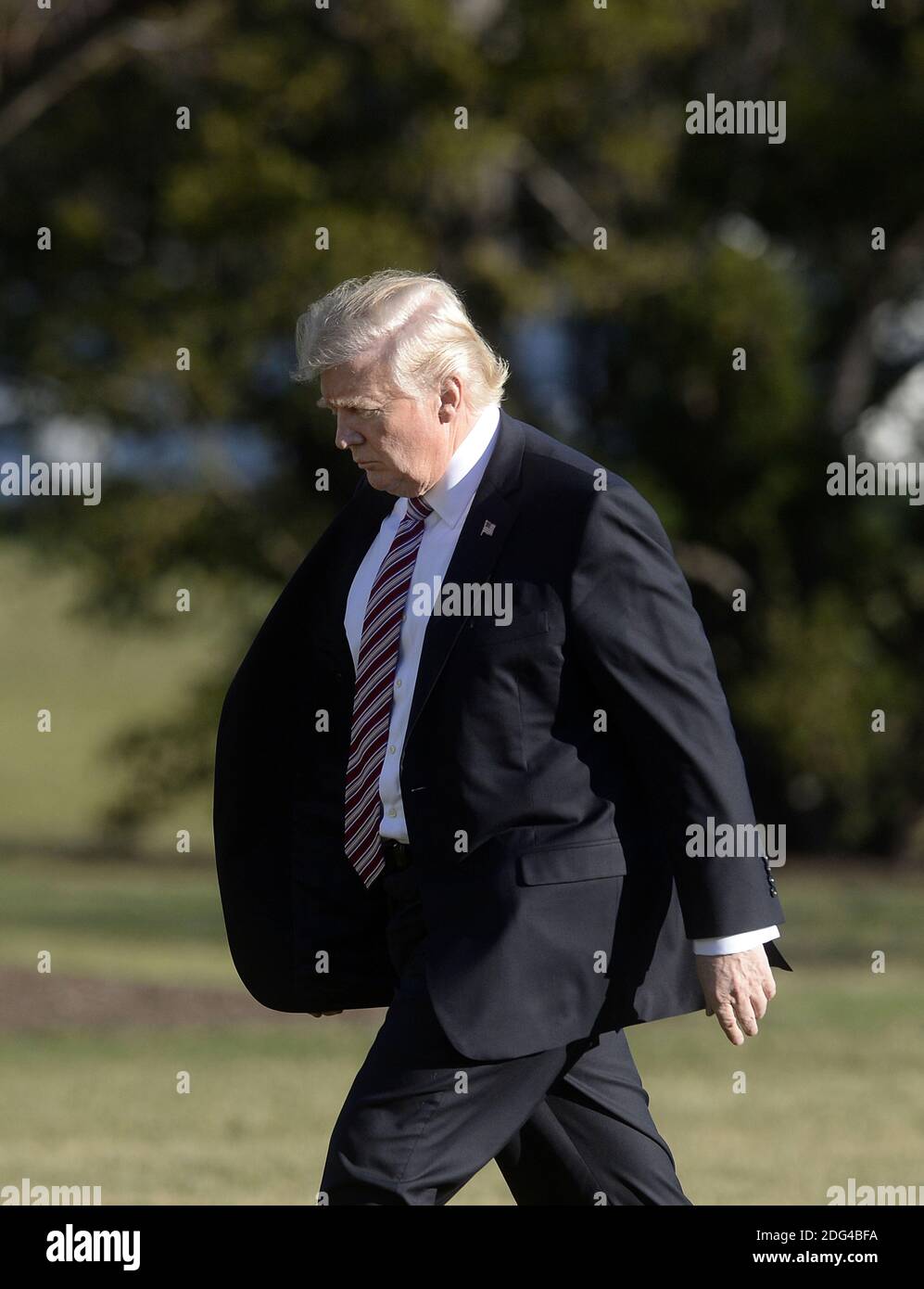 US President Donald Trump walks back to the Oval Office of the White ...