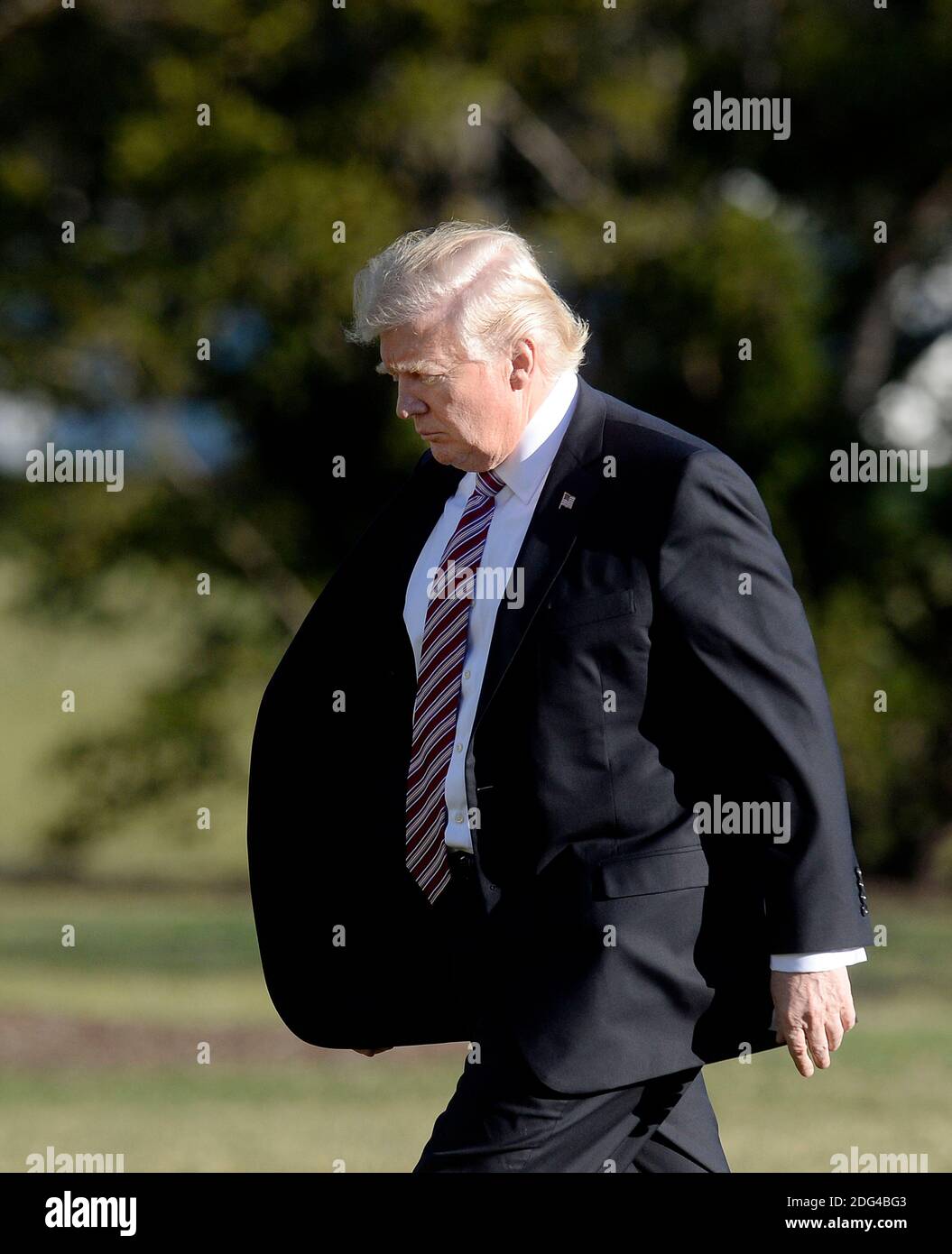 US President Donald Trump walks back to the Oval Office of the White ...