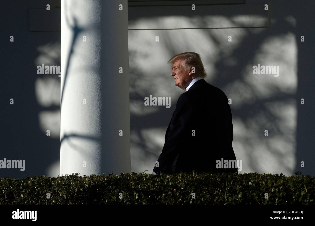 US President Donald Trump walks back to the Oval Office of the White ...