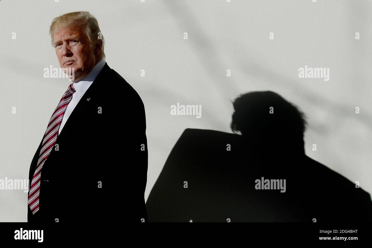 US President Donald Trump walks back to the Oval Office of the White ...