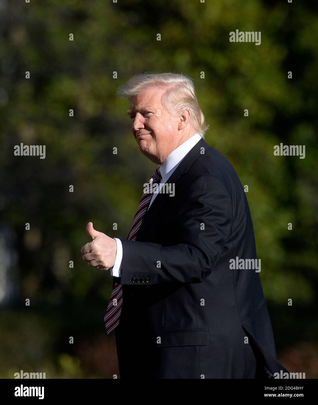 US President Donald Trump walks back to the Oval Office of the White ...