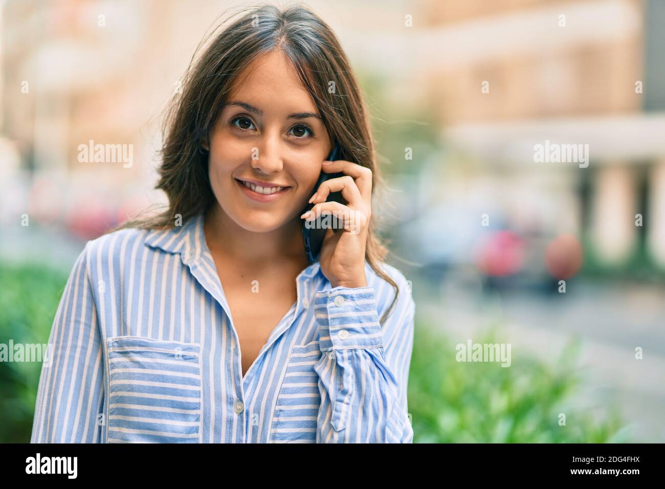 Young hispanic woman smiling happy talking on the smartphone at the ...