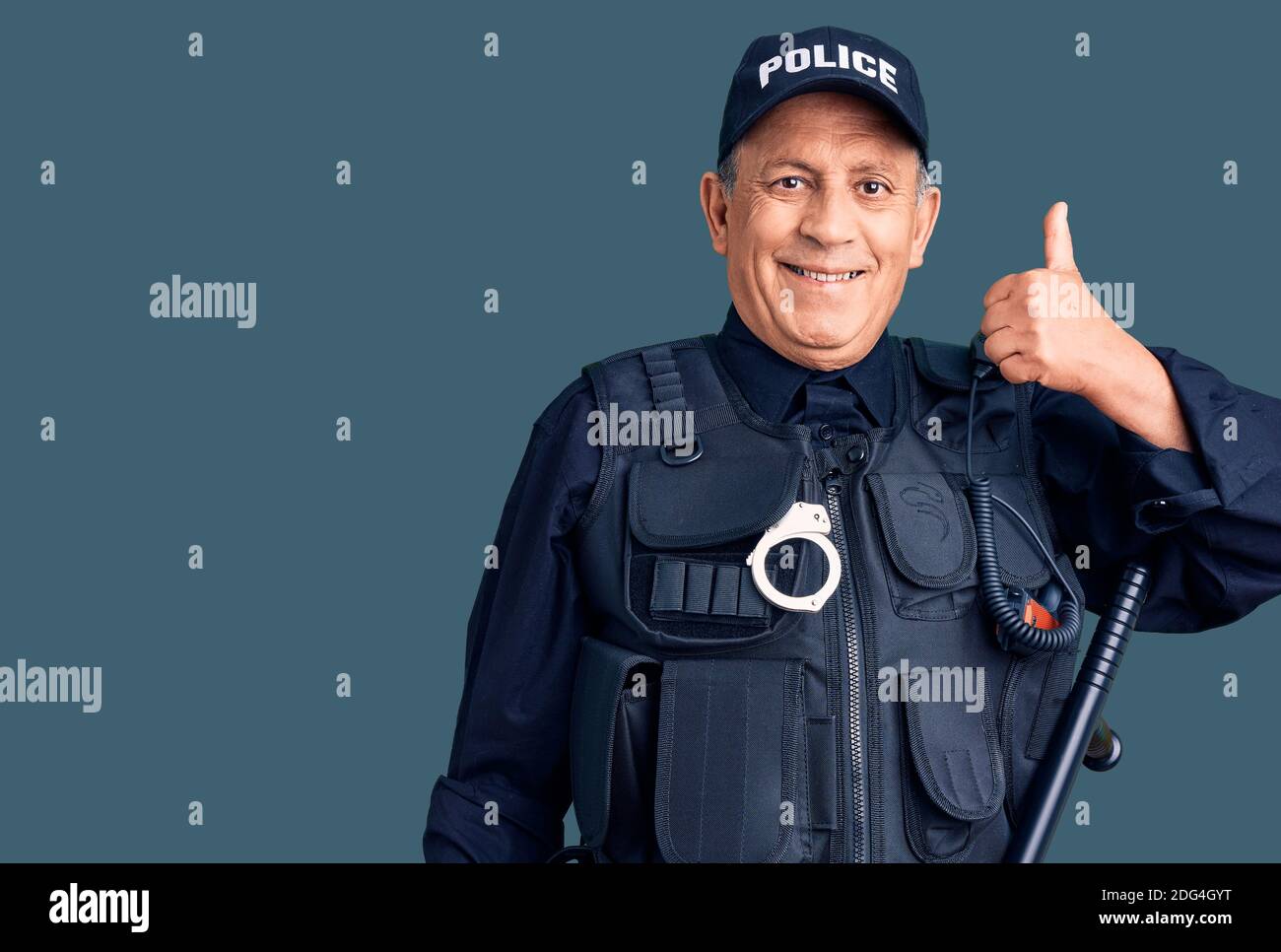 Senior handsome man wearing police uniform smiling happy and positive,  thumb up doing excellent and approval sign Stock Photo - Alamy