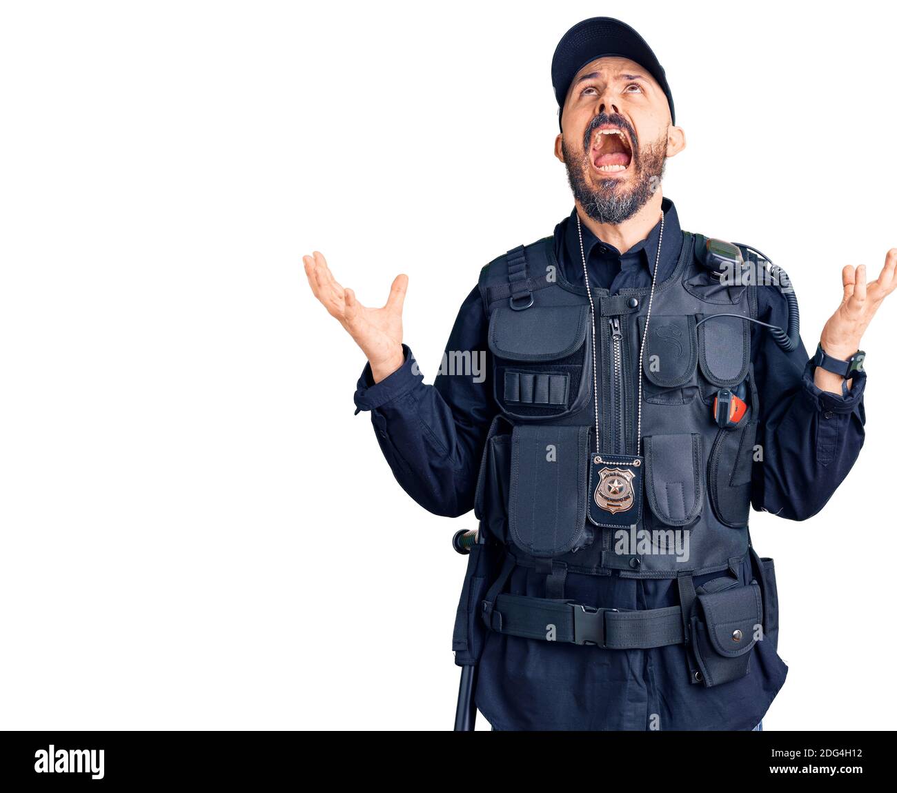Young handsome man wearing police uniform crazy and mad shouting and yelling with aggressive expression and arms raised. frustration concept. Stock Photo