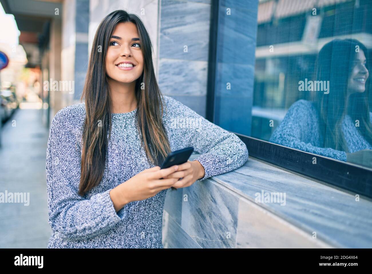 Young beautiful hispanic girl smiling happy using smartphone at the ...