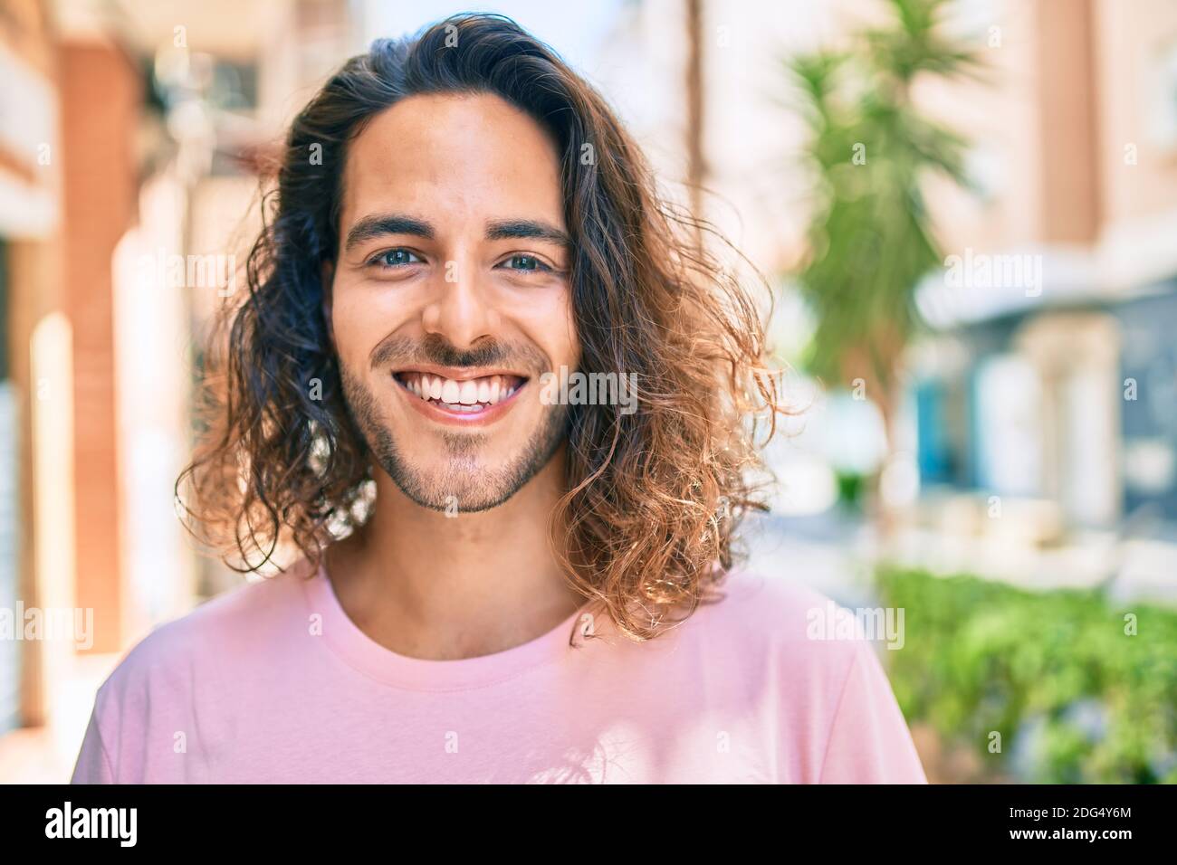 Young hispanic man smiling happy looking to the camera at city Stock ...